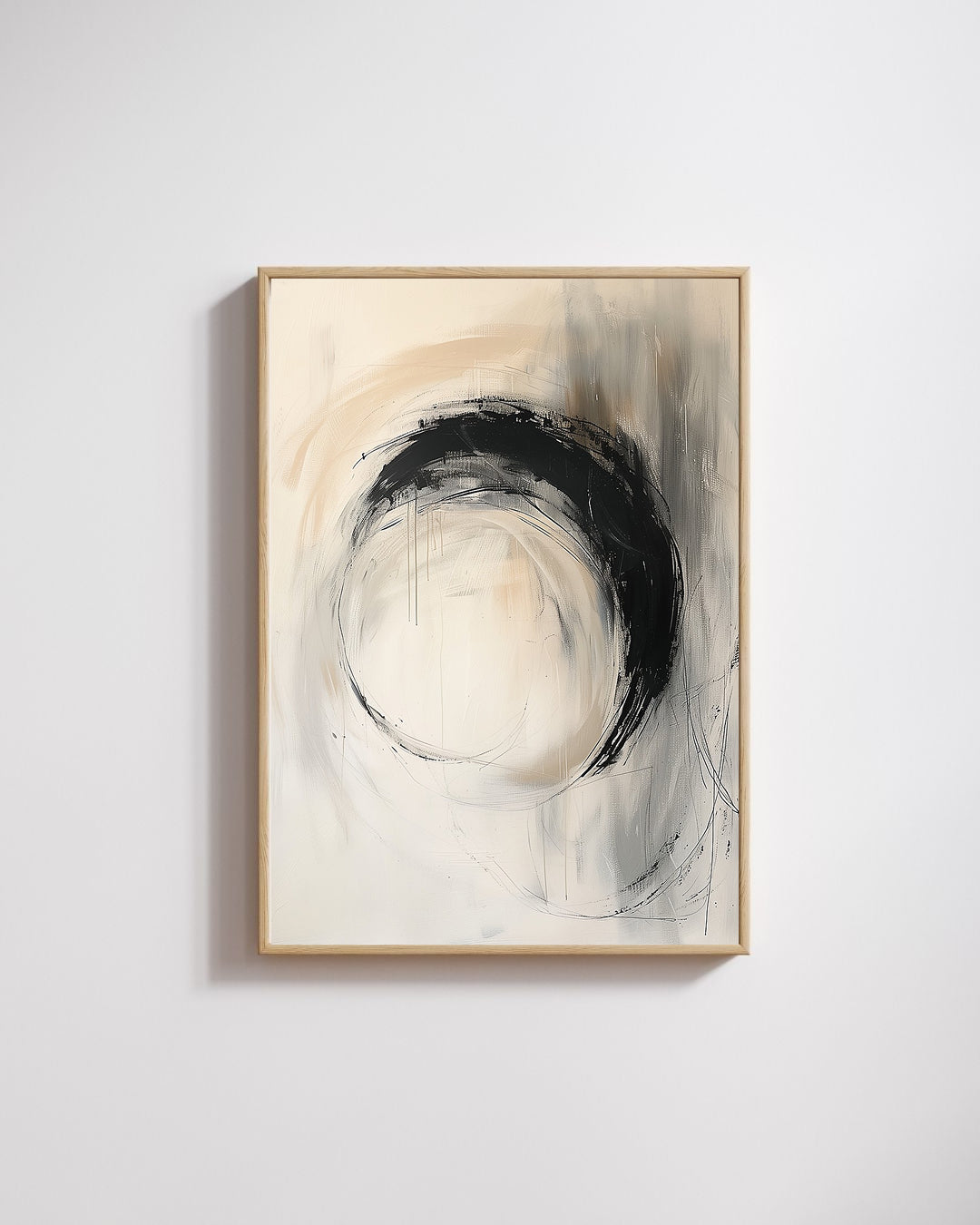 Abstract art piece with circular design in black and white, framed in gold on a light gray wall.